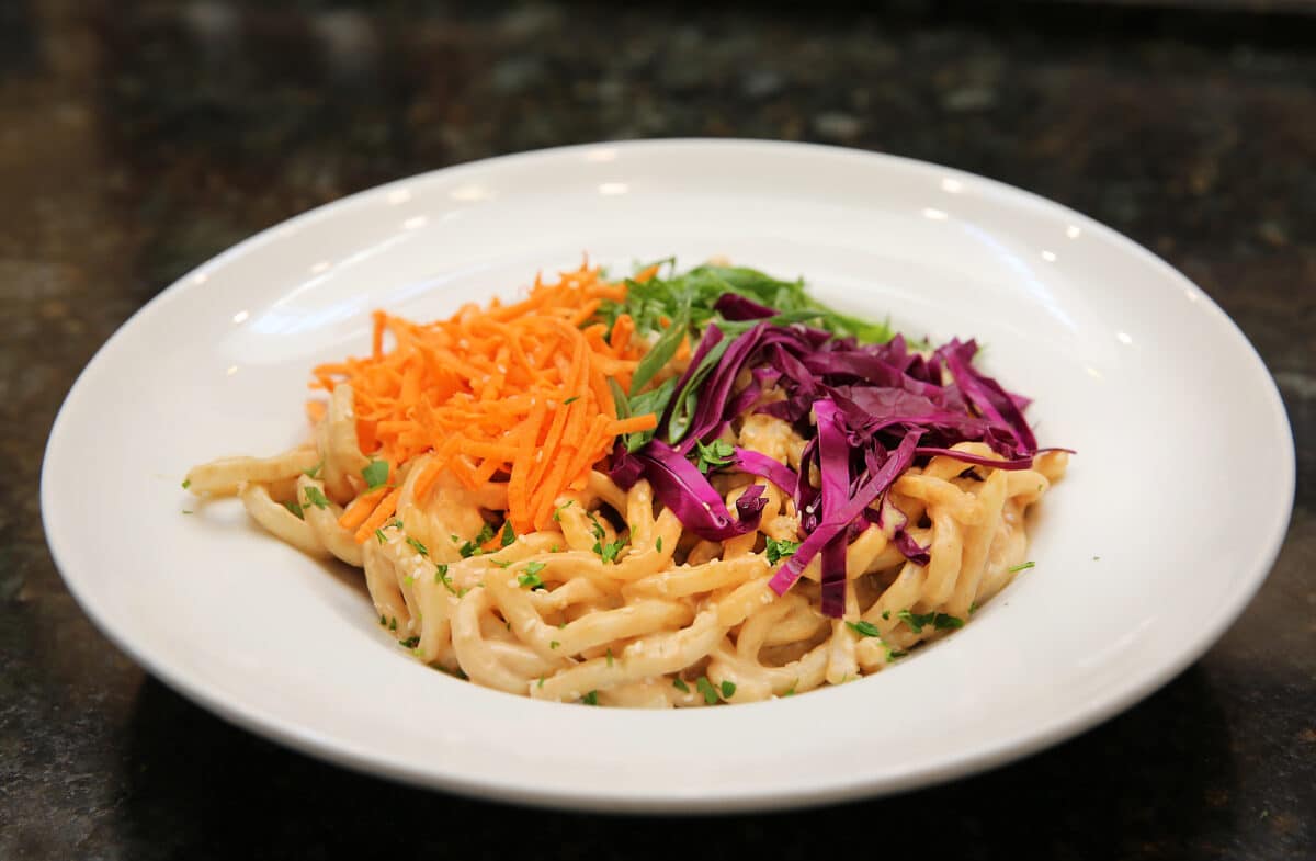 Asian Peanut Cold Noodle Salad featuring udon noodles, shredded purple cabbage, carrot, scallions, and peanut sesame dressing.