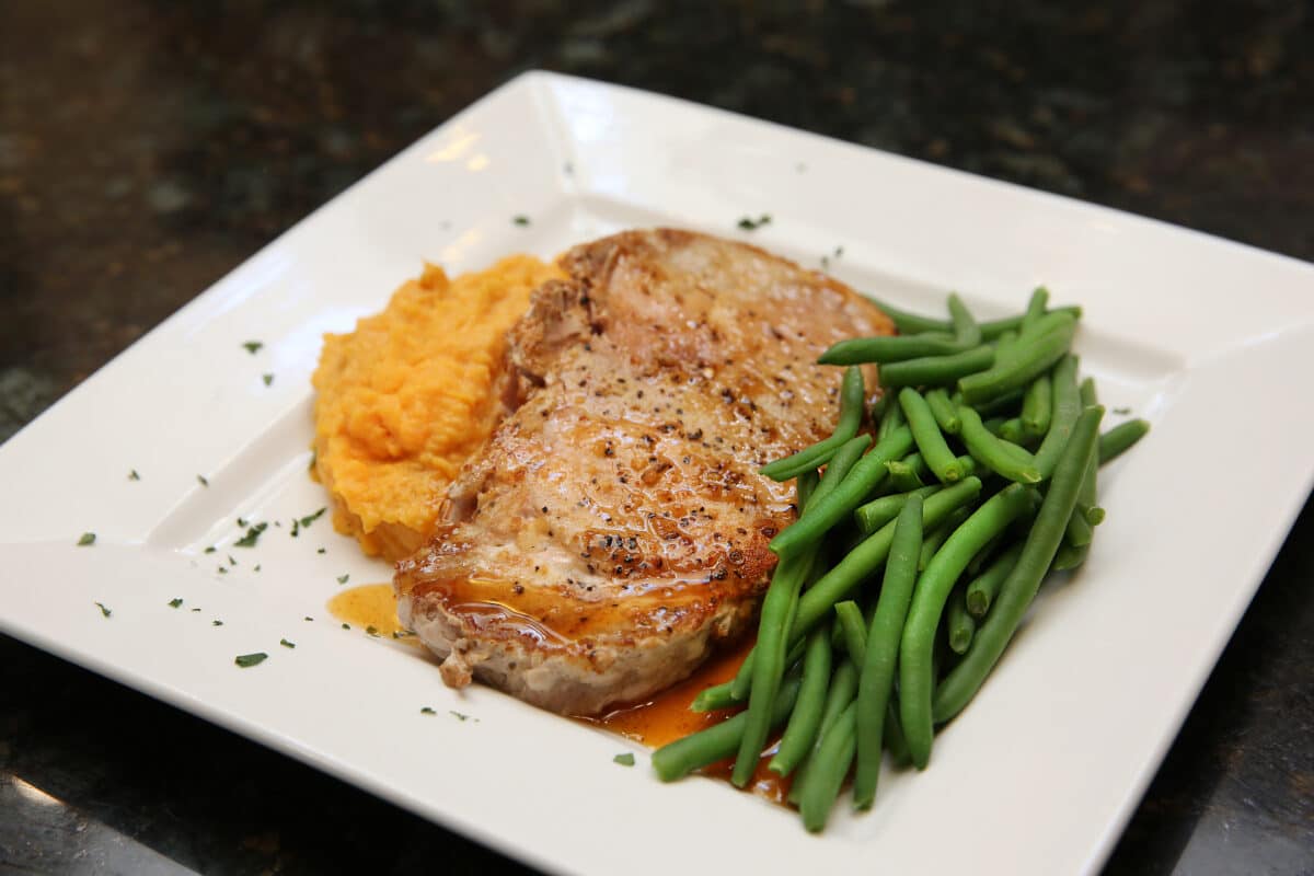 Fire Honey Glazed Porkchop served with sweet potato mash and green beans.