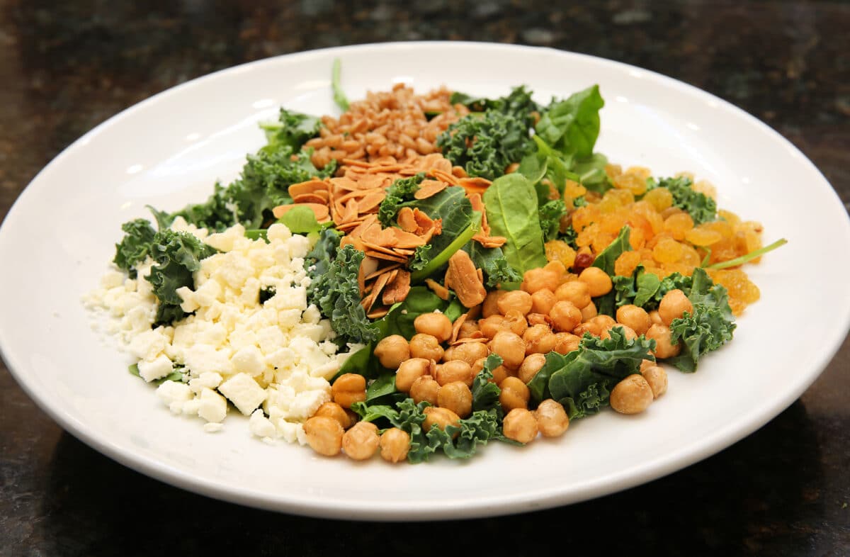 Lake Effects Grain Bowl featuring farro, kale, spinach, chickpeas, golden raisins, toasted almonds, and feta cheese.